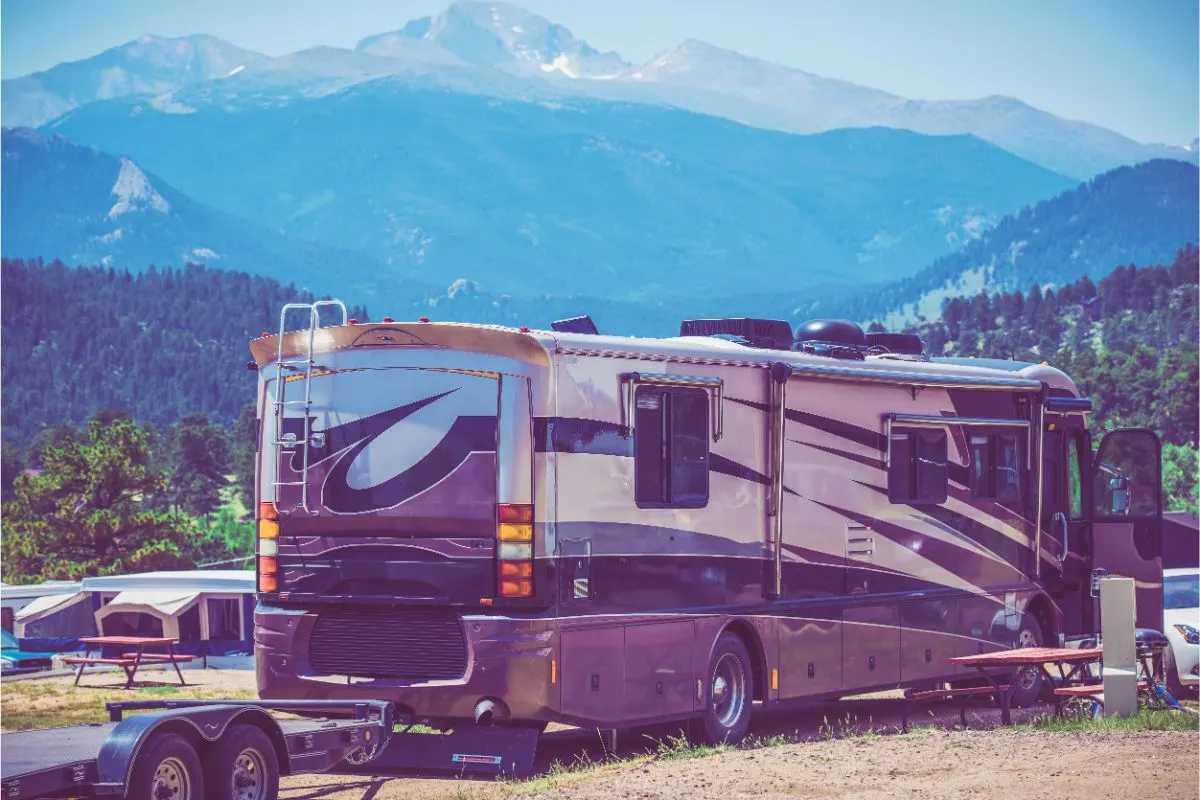 Back and side view of class a rv stopping by for a camp.