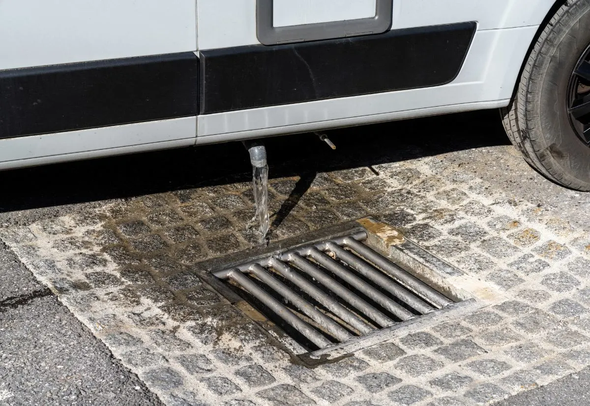 A water from RV water tank draining out on the drainage.