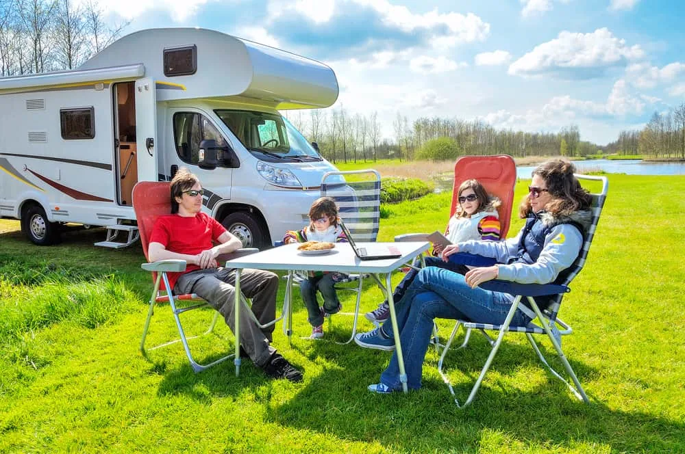 A family camping by the river with their RV.