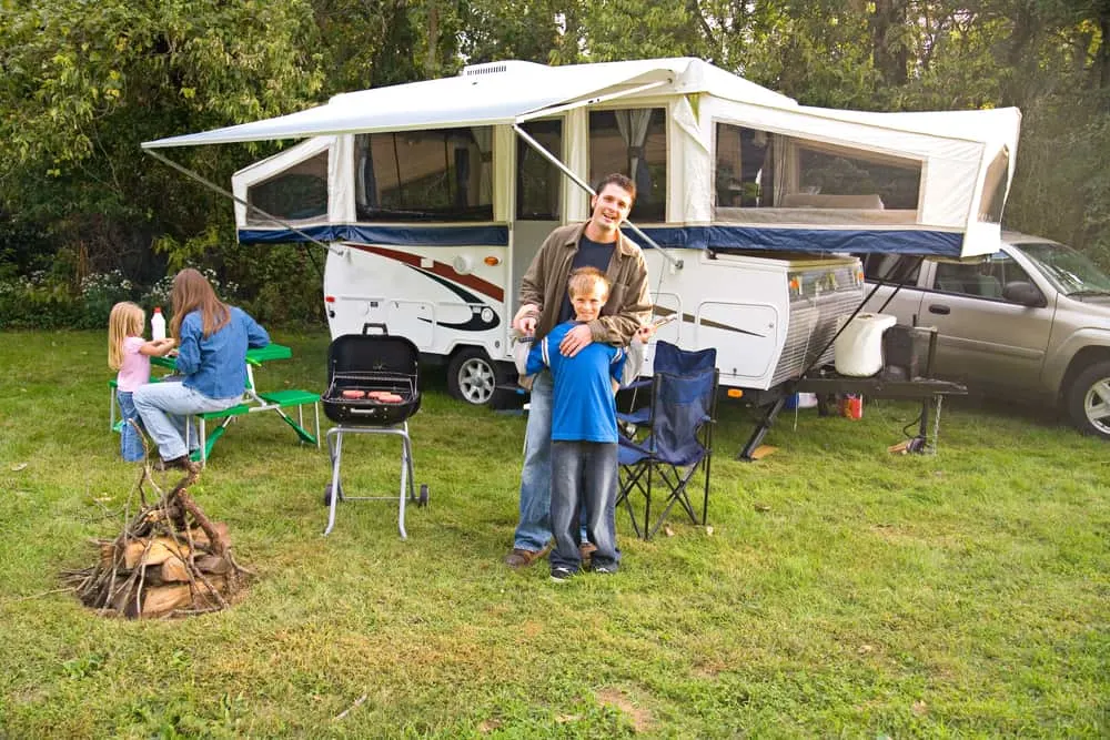 This is a close look at a family camping with their pop-up camper.