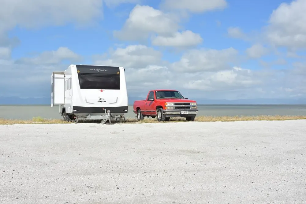 Jayco Jay Sport Camping Trailer parked at a camping site with a red truck.