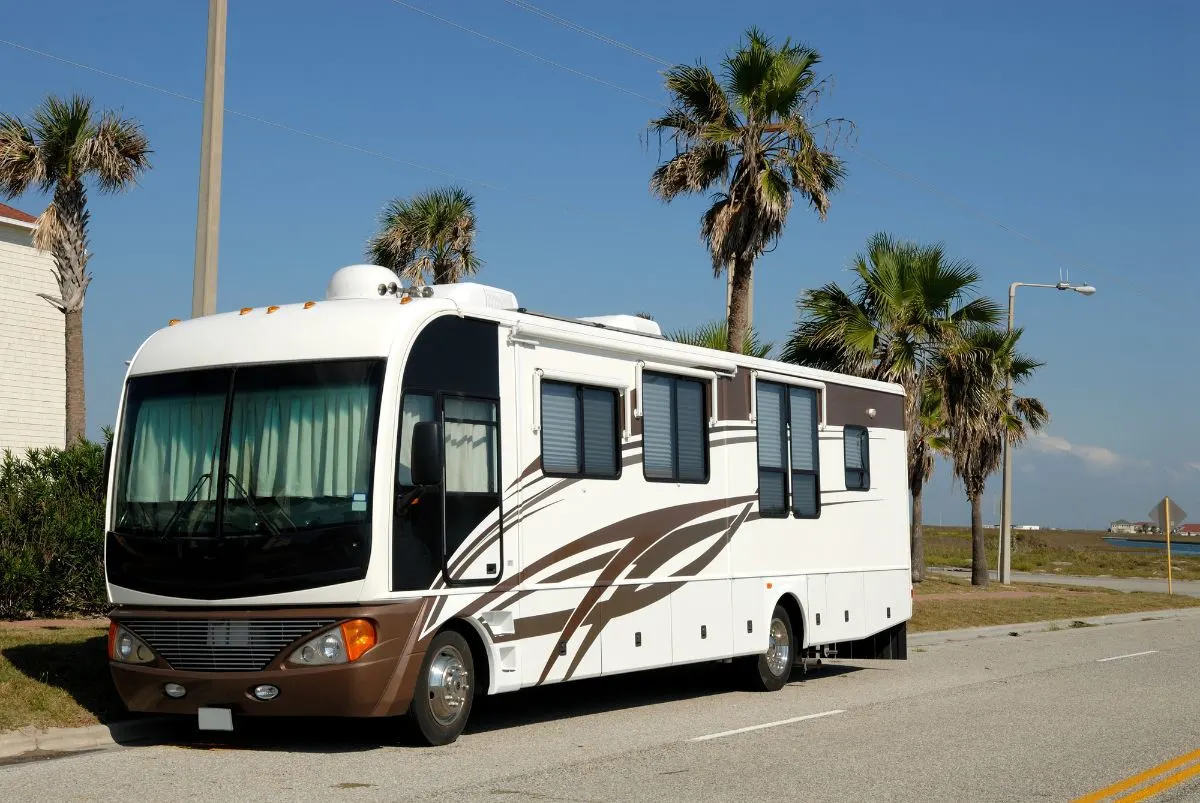 A motorhome toy hauler in road side walk.