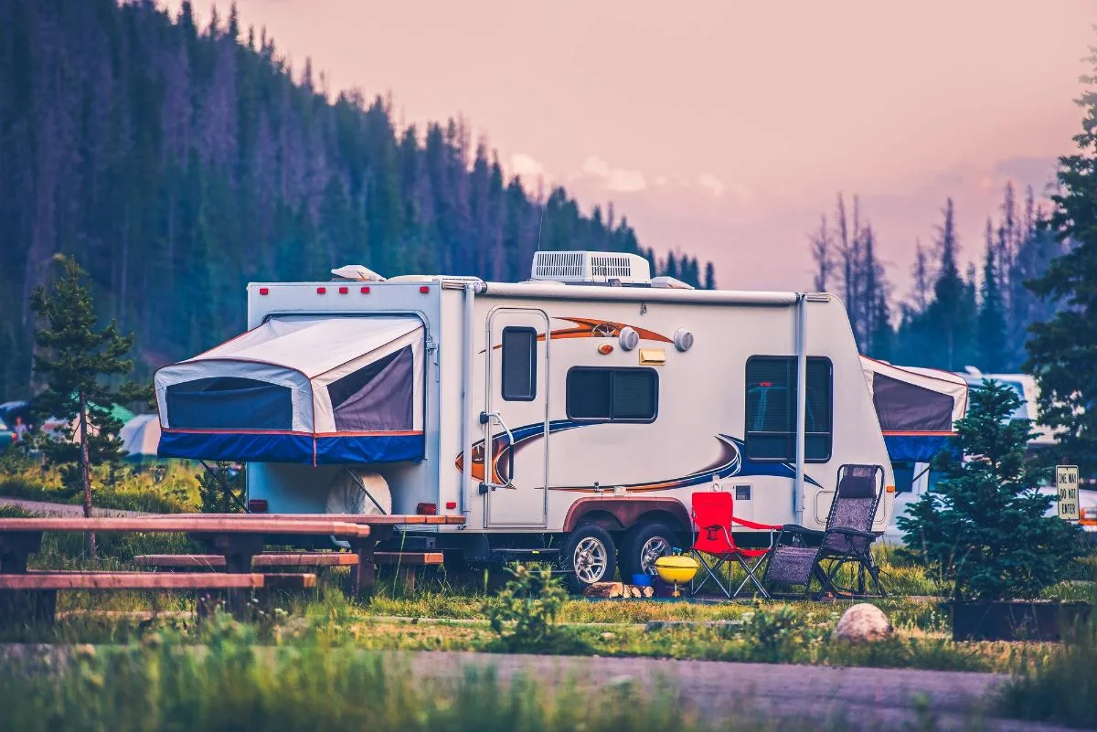 A pop-up camper on mountain area camping site.