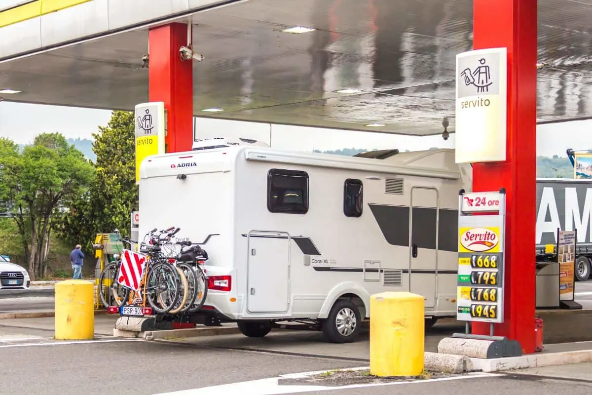 An RV stops to gas up at a gas station.