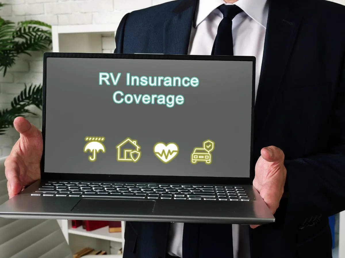 A RV insurance agent holding a laptop.