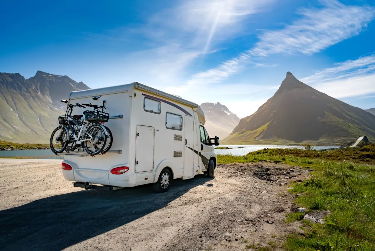 An RV parked near the river.