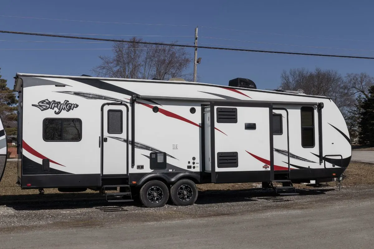 Side view of white Toy Hauler standby beside the road.