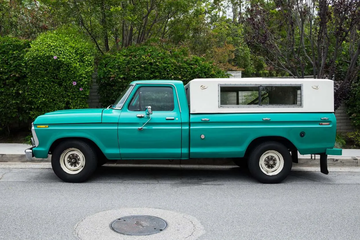 Pickup truck canopy parked at the side of the road.