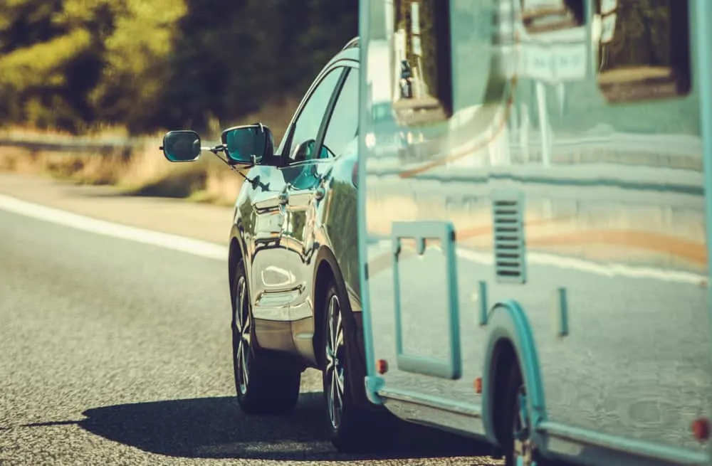 This is a close look at a car pulling a travel trailer behind.