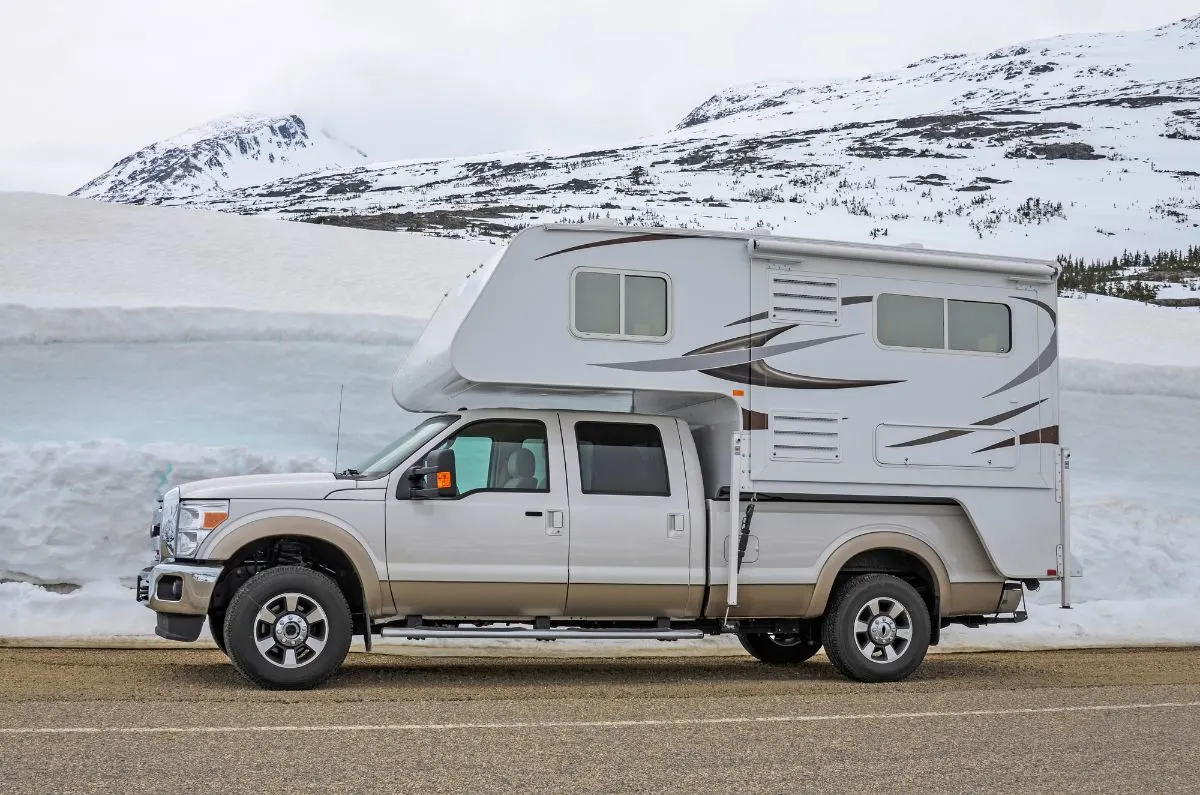 A Truck camper on road.