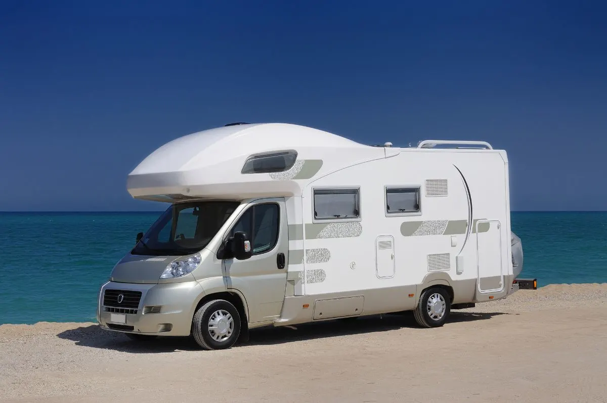 A camper van parked near the sea.