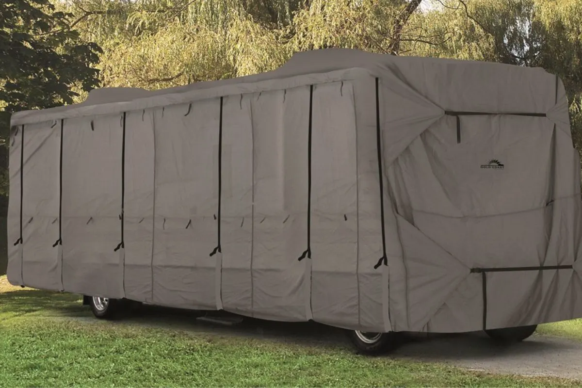 A perfectly fit waterproof RV covers park outside the grass field.