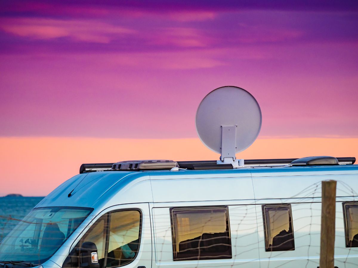 A side view of an RV parked near the sea.