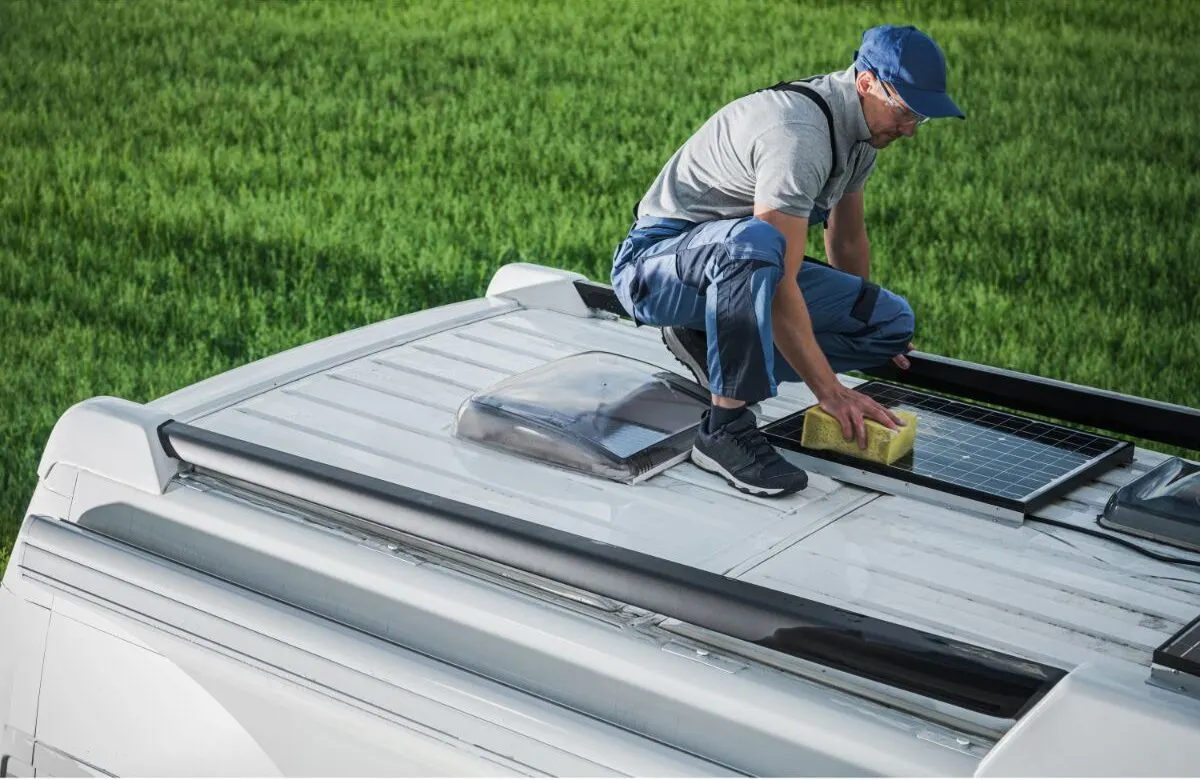 A photo of man at the roof of recreational van.