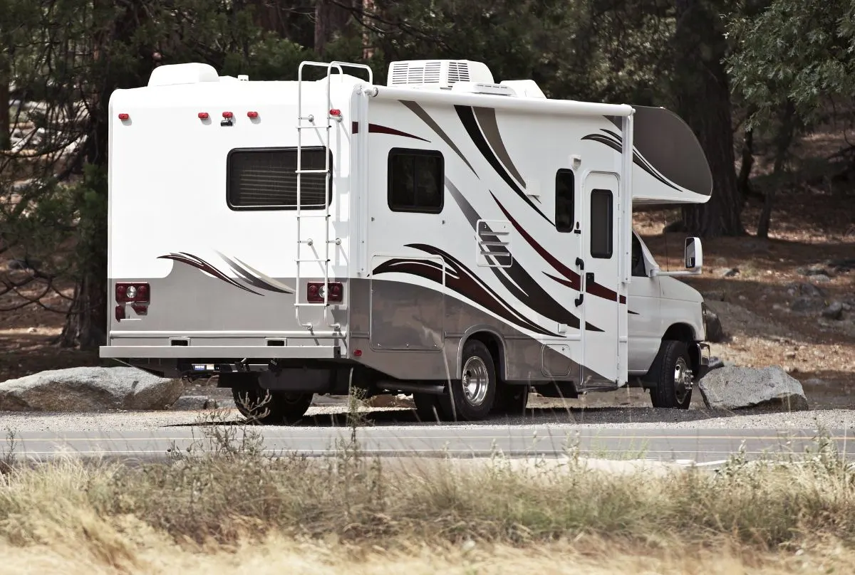 Back view of a Class C RV on camp site.