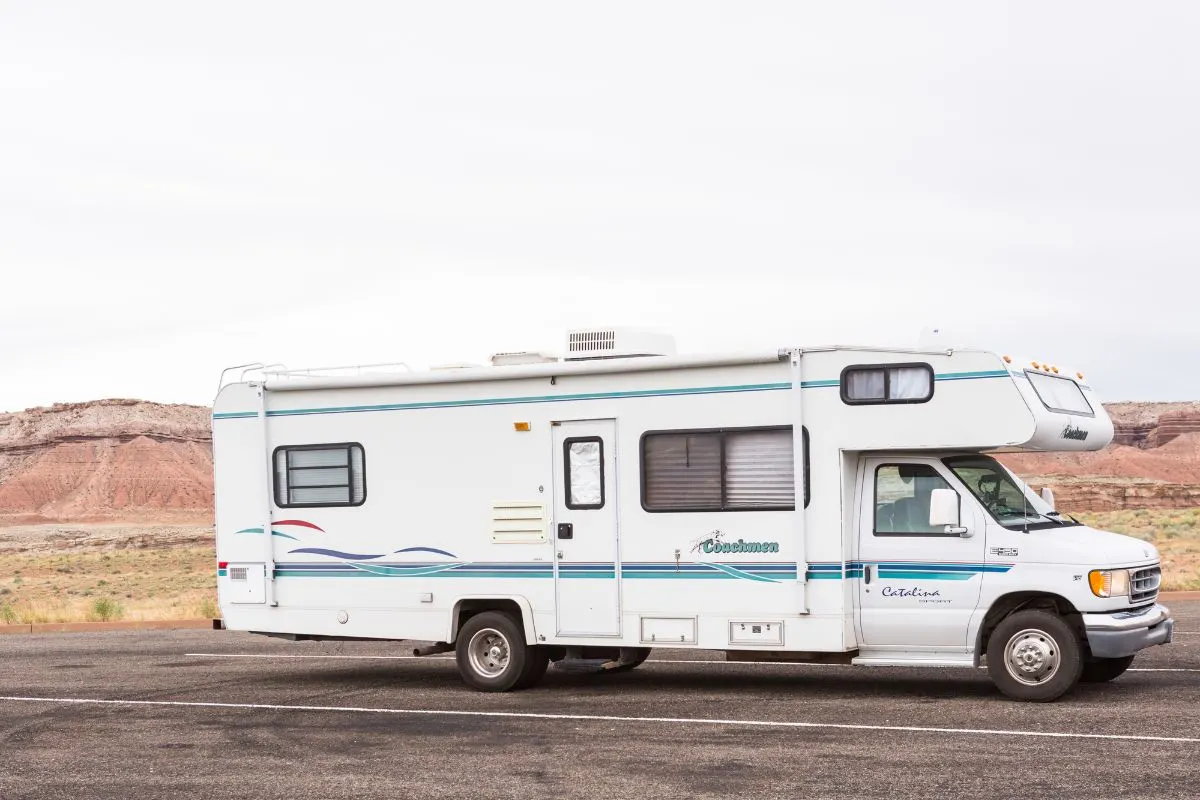 Side view of a Class C RV on road.