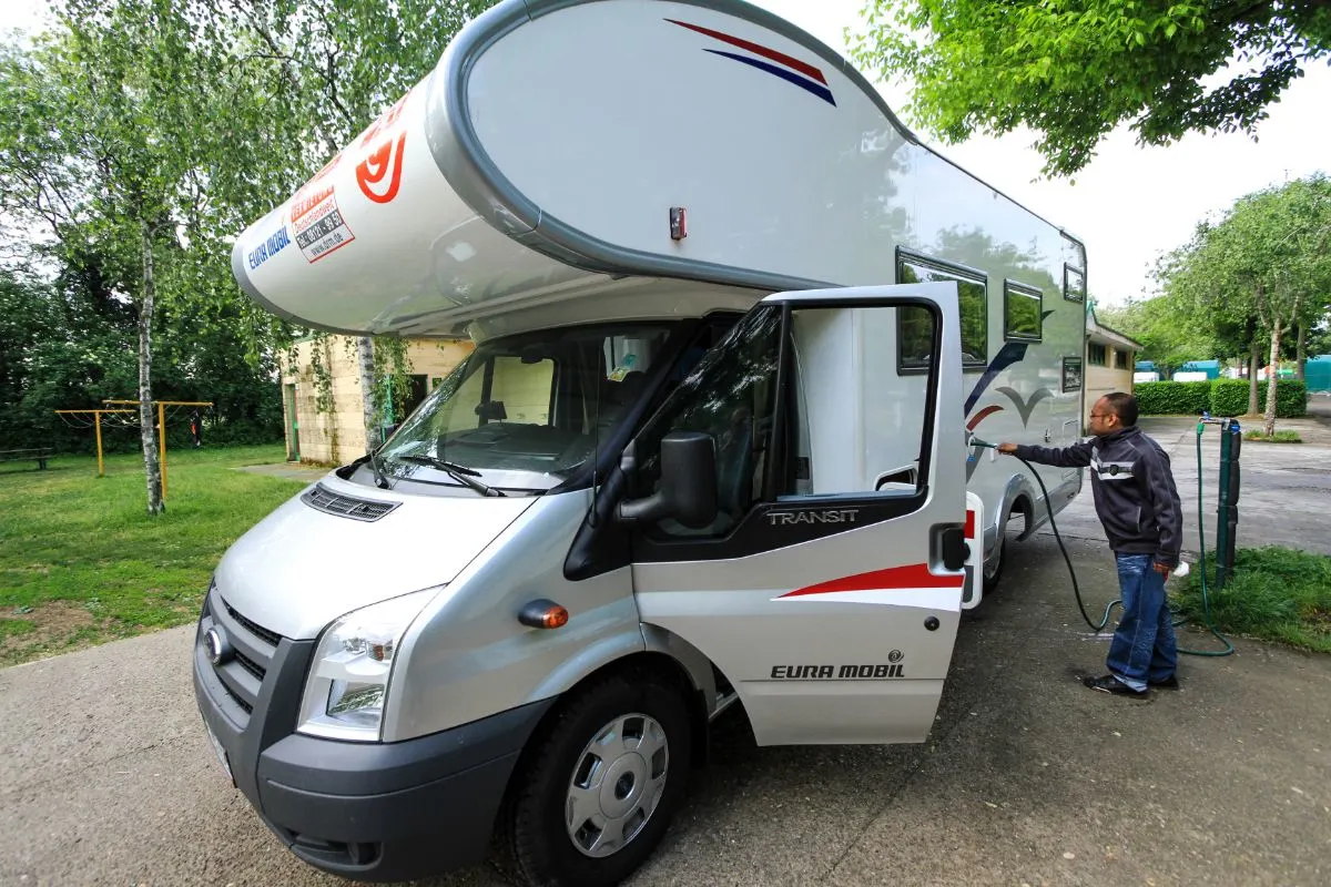 Man refilling fresh water on his RV.