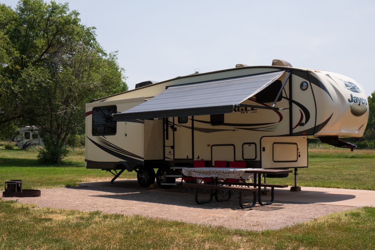 RV on camp site with awning extended.