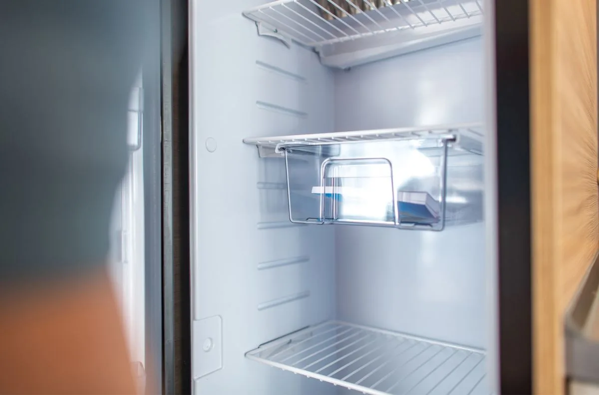 An empty refrigerator inside an RV.