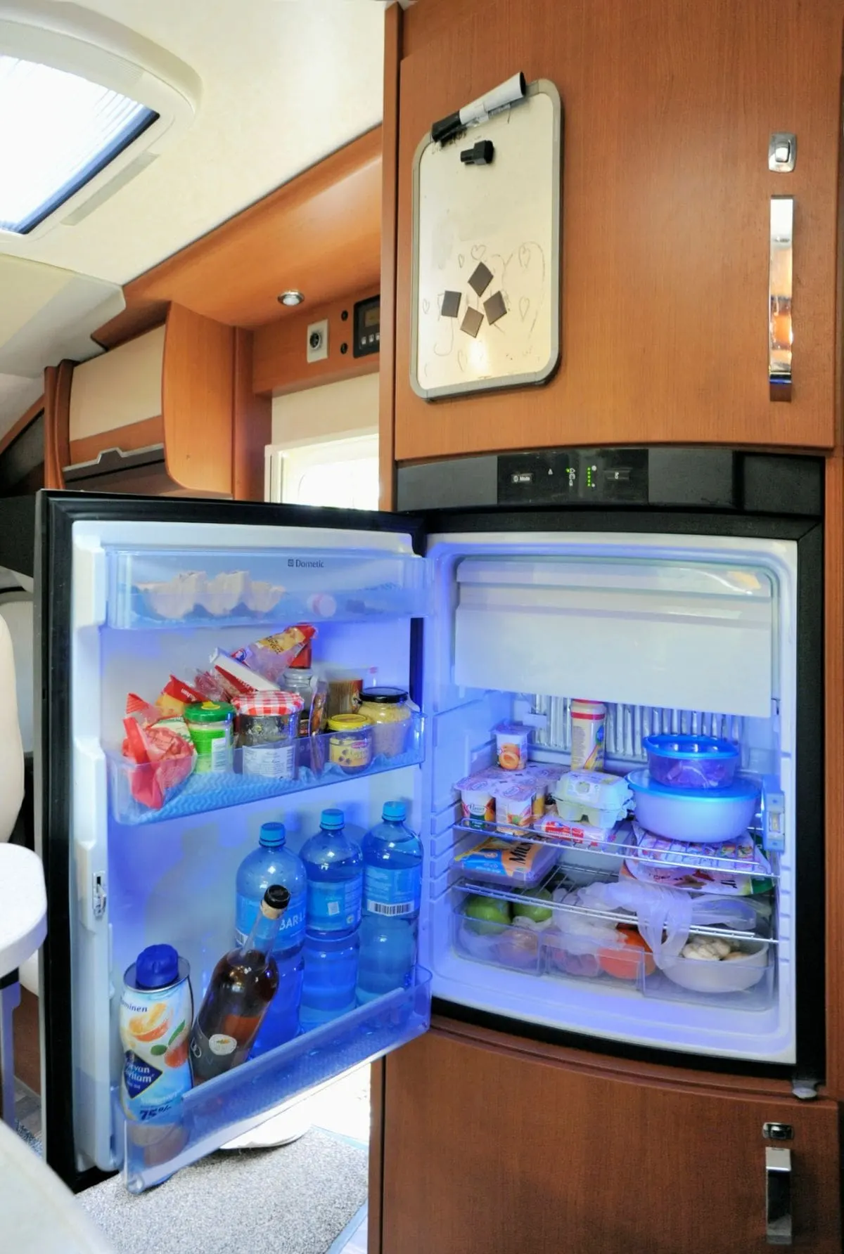 An open RV refrigerator inside an RV. 