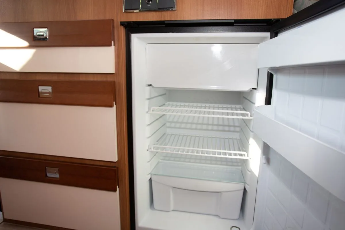 An open empty refrigerator inside an RV.