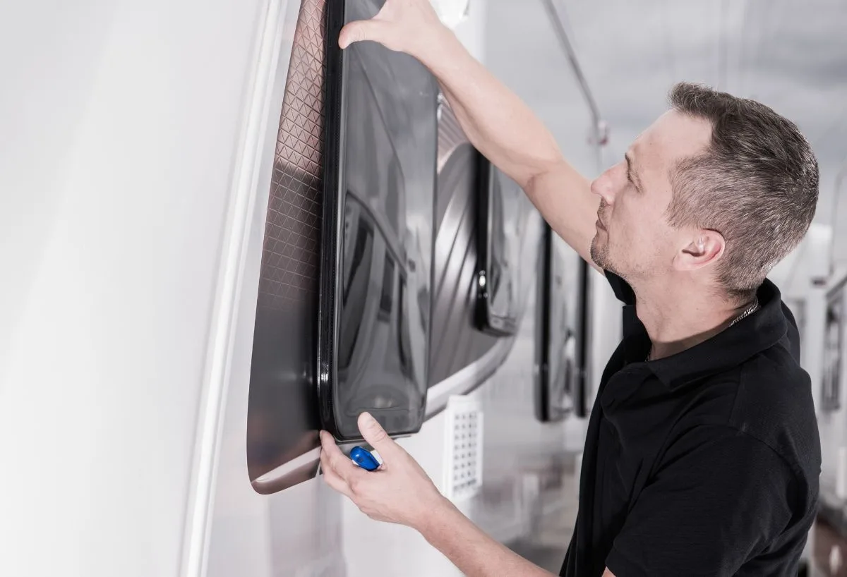 A man installing window in RV.