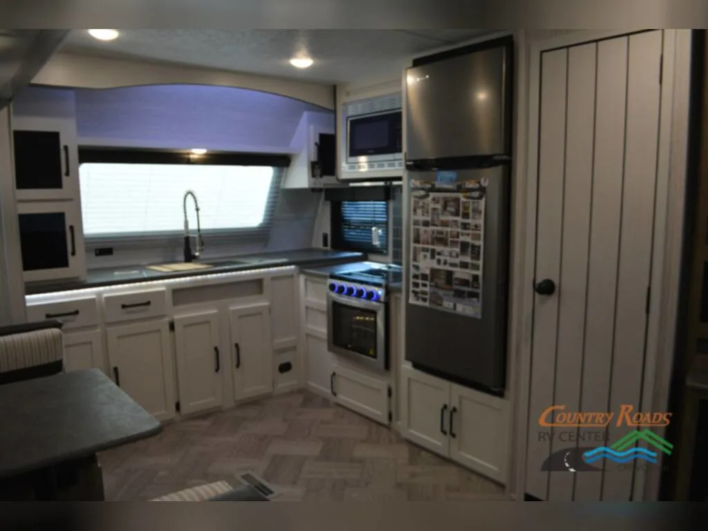 Kitchen with a fridge, cabinet, sink and gas burner.