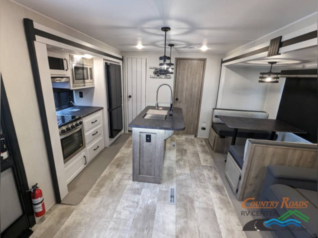 Interior of the RV with a dinette, sofas and a kitchen.