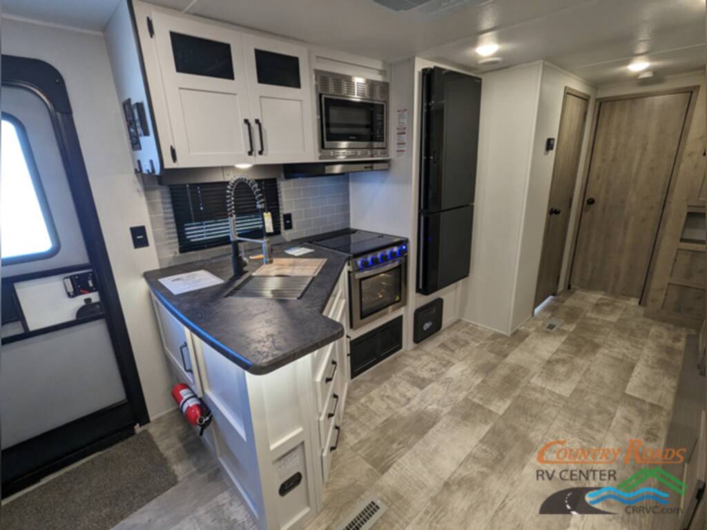 Kitchen with a sink, gas burner, fridge and cabinets.