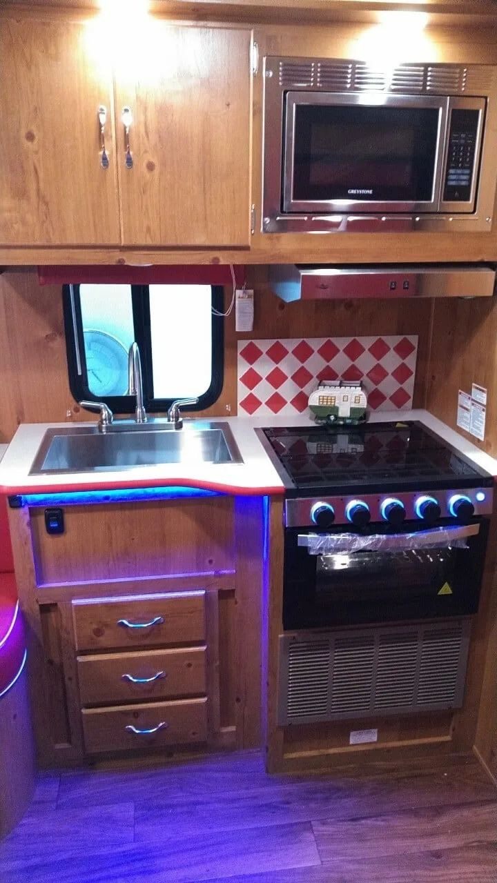 Cooking area with a burner, oven and a sink.