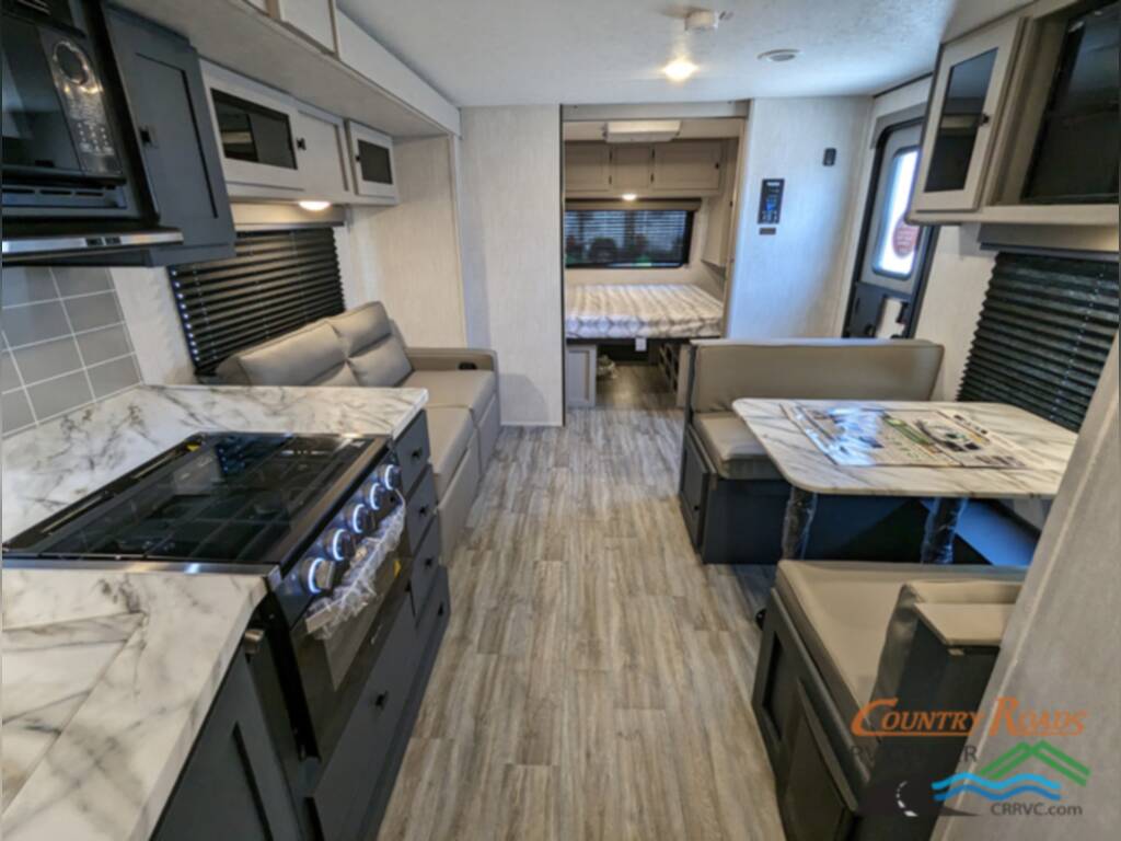 Interior of the New 2024 Coachmen APEX 300BHS Travel Trailer RV with a dinette and kitchen.