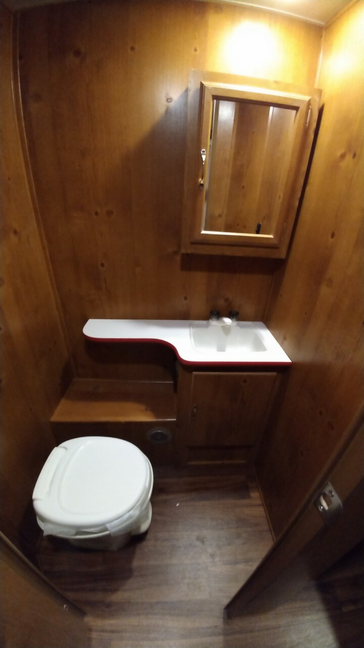 Toilet with a sink and a cabinet.