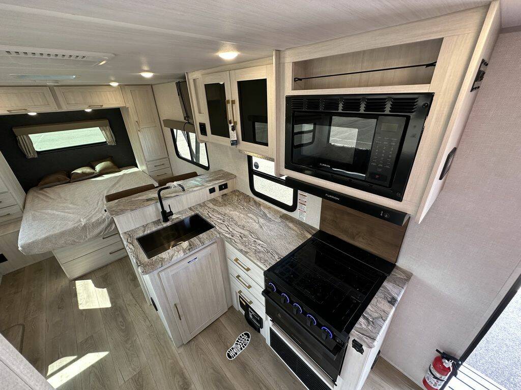 Interior view of the New 2024 Forest Surveyor Legend 202RBLE Travel Trailer RV with a kitchen and bedroom.