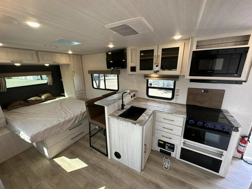 Interior view of the New 2024 Forest Surveyor Legend 202RBLE Travel Trailer RV with a kitchen, breakfast nook and bedroom.