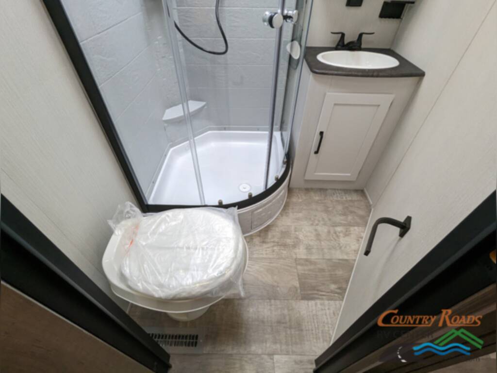 Bathroom with a toilet, sink and a walk-in shower.