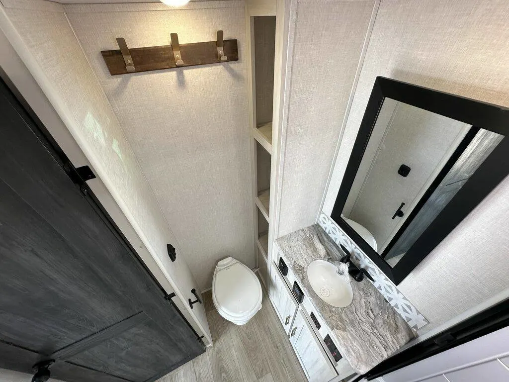 Bathroom with a toilet, sink and linen.