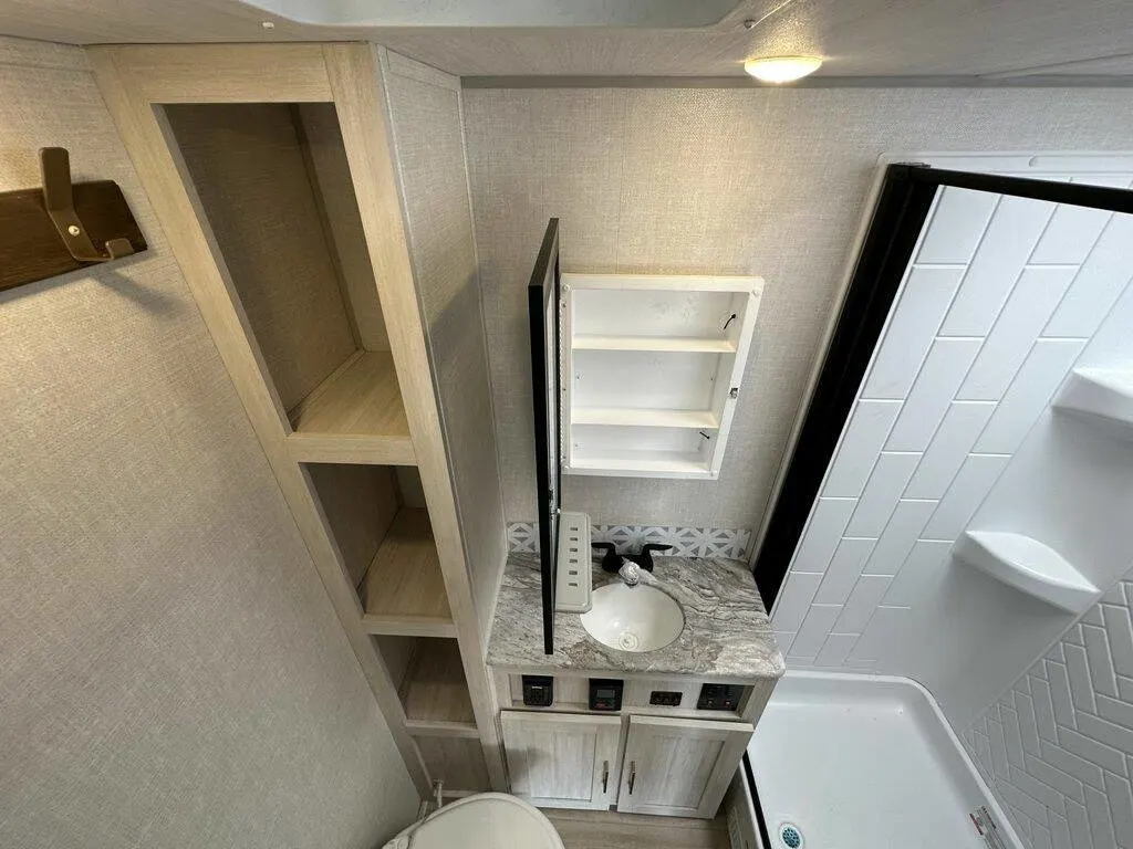 Bathroom with a toilet, sink, shower and linen.