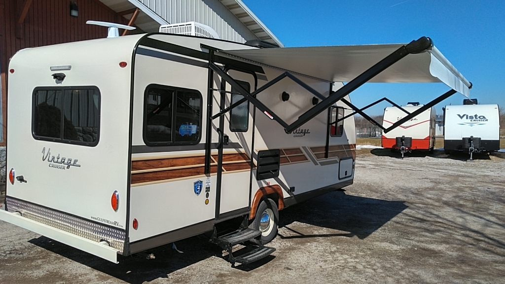 Side view of the RV with a camping tent.