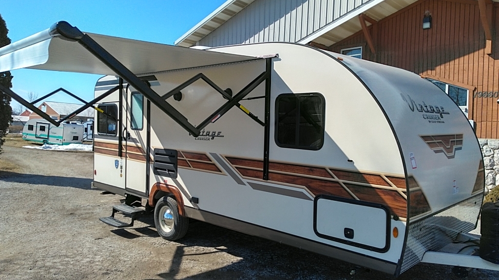 Side view of the RV with a camping tent.