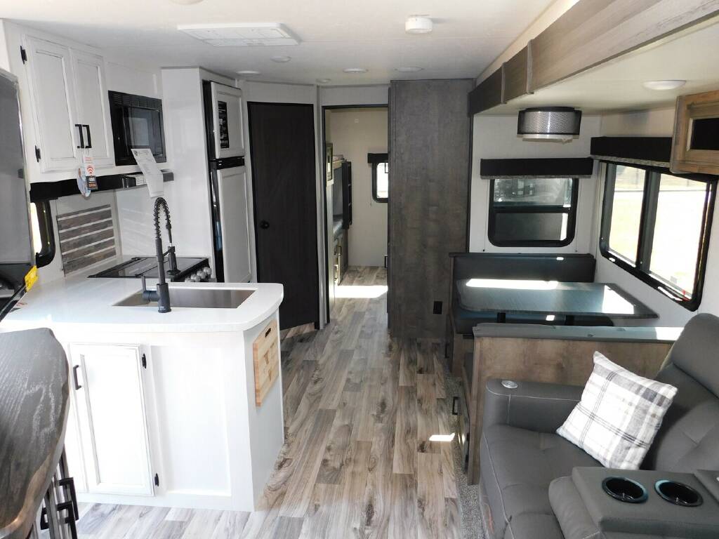 Interior view of the RV with a dinette, living space and a kitchen.