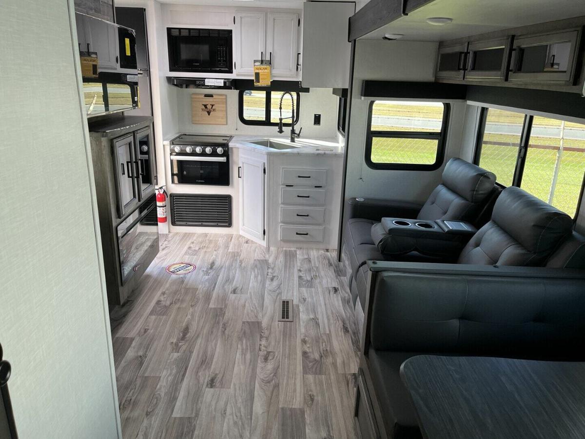 Interior view of the RV with a dinette, living space and a kitchen.