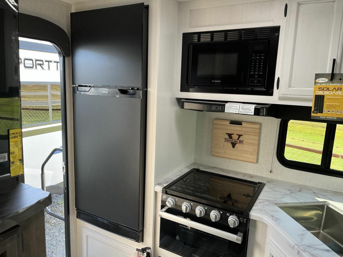 Kitchen with a gas burner, fridge, oven, sink and cabinets.