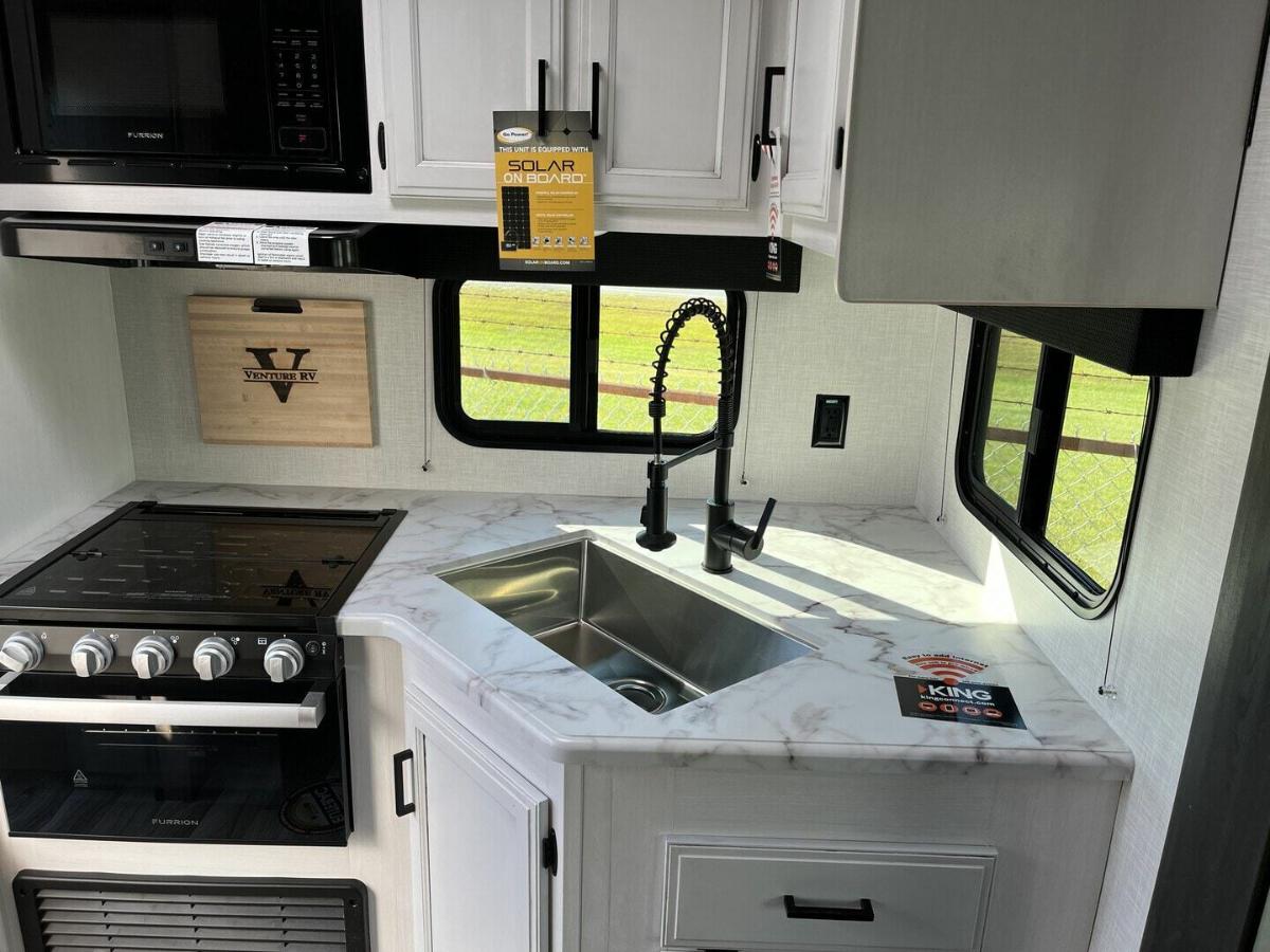 Kitchen with a gas burner, oven, sink and cabinets.