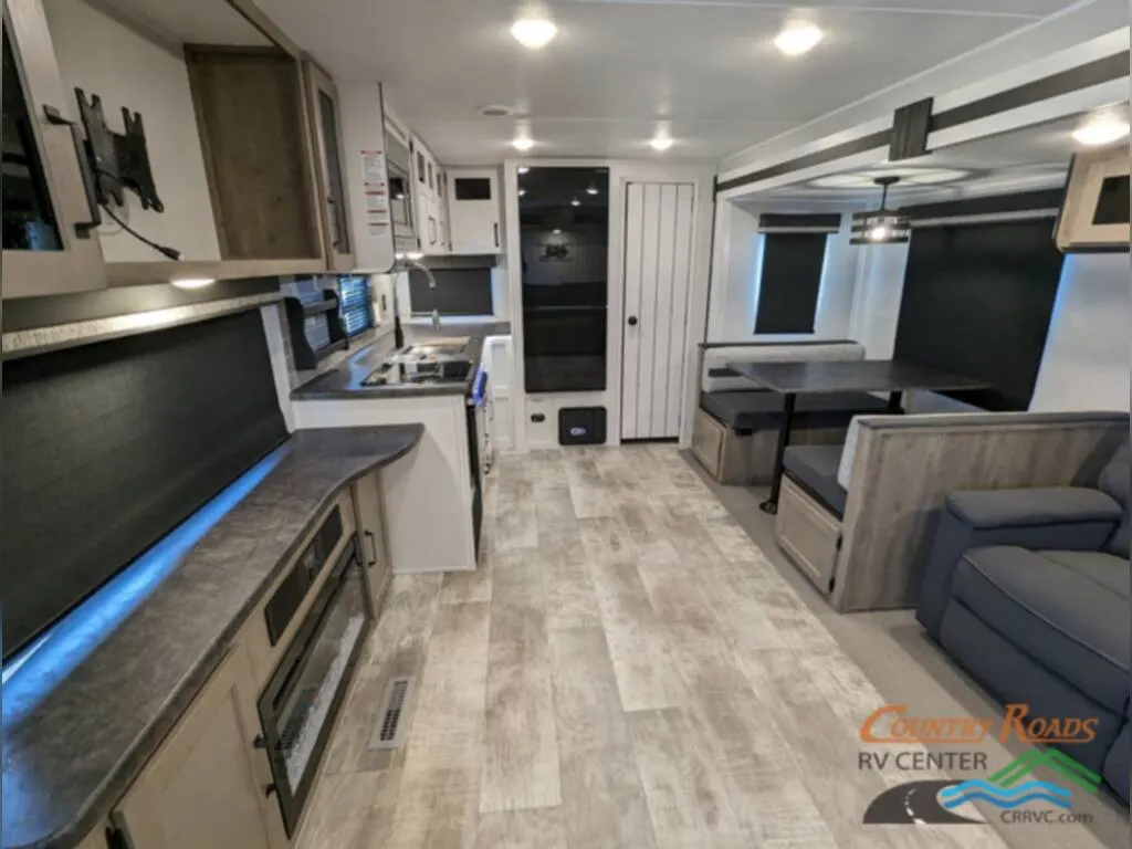 Interior of the New 2024 Palomino PUMA 30RKQS Travel Trailer RV with a dinette and a kitchen.