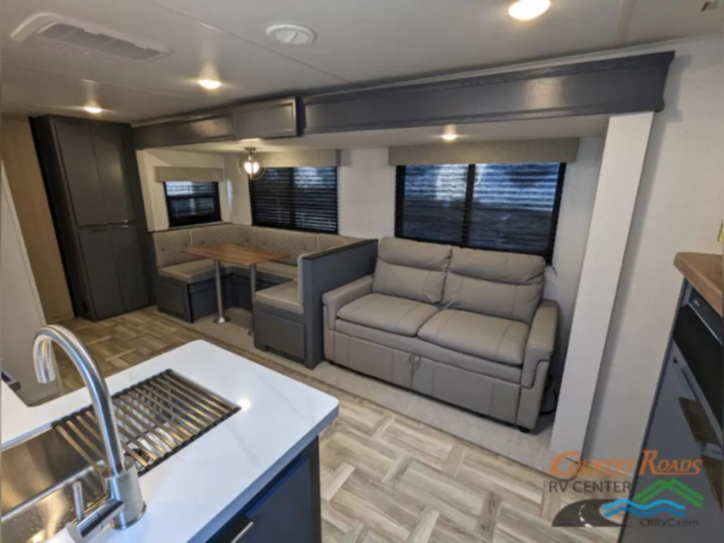 Interior of the New 2024 Prime Time TRACER 31BHD Travel Trailer RV with a dinette and reclining chairs.