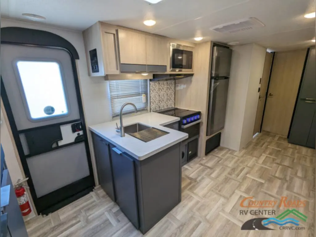 Kitchen with a fridge, gas burner, oven, and a sink.