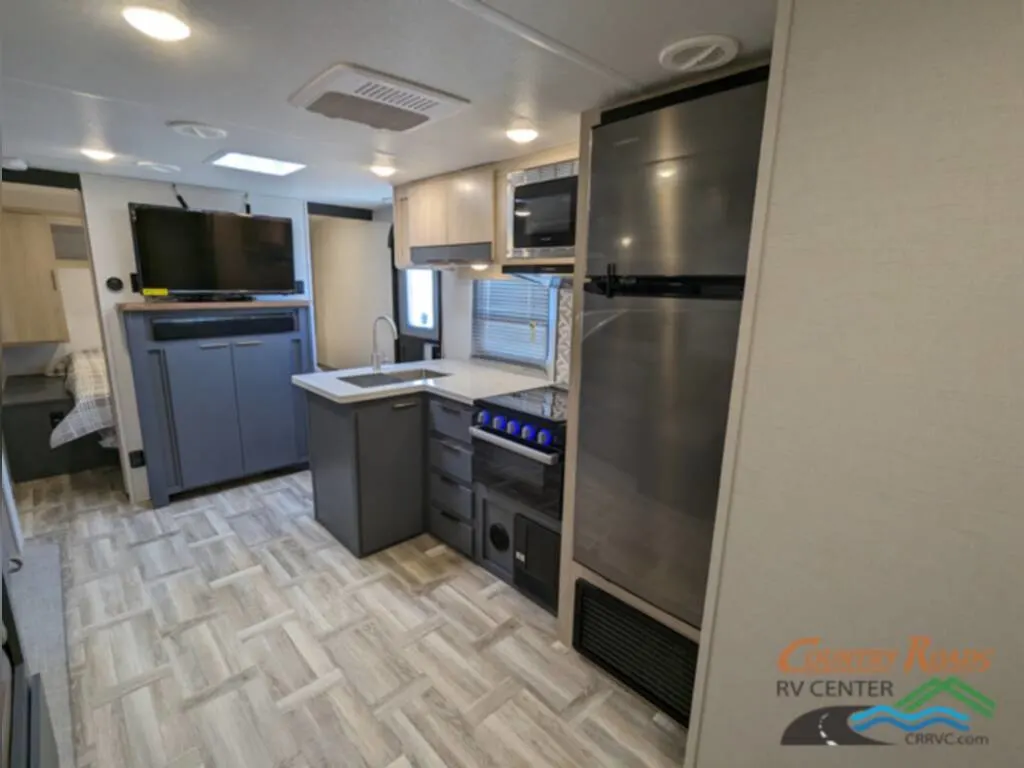 Kitchen with a fridge, gas burner, oven, and a sink.