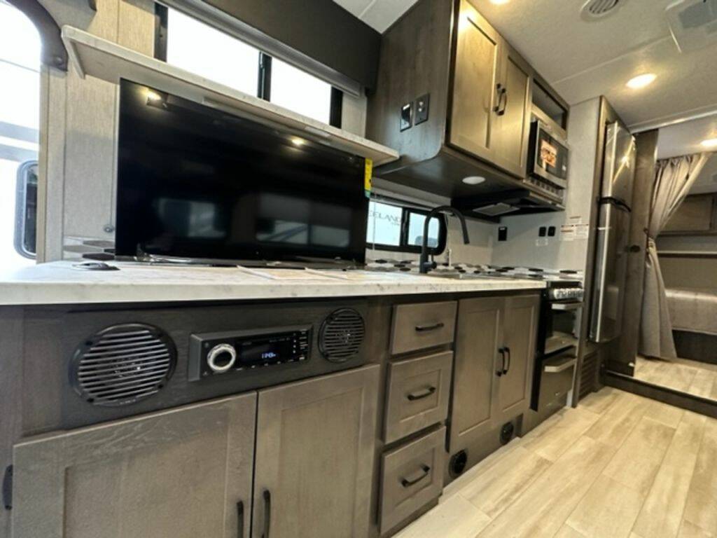 Kitchen with a gas burner, fridge, oven, sink and cabinets.