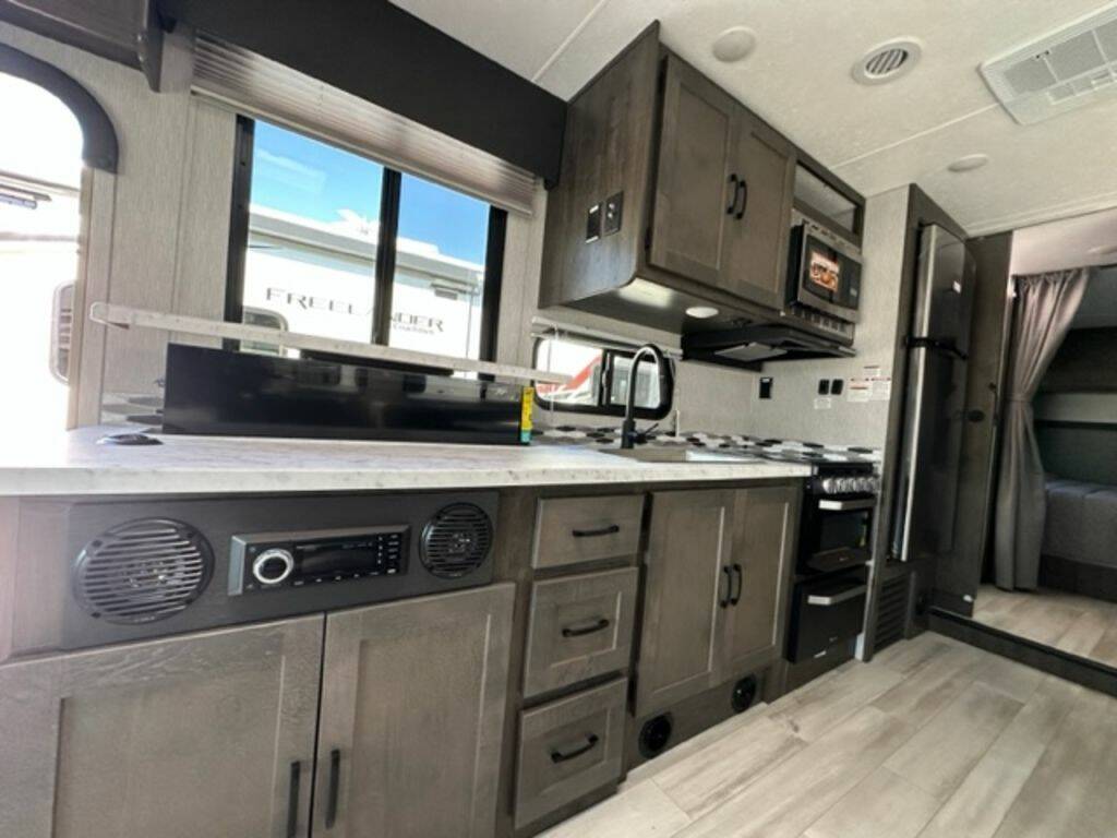 Kitchen with a gas burner, fridge, oven, sink and cabinets.