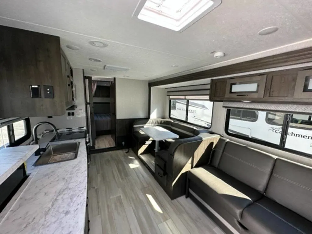 Interior view of the RV with a dinette, living space and a kitchen.